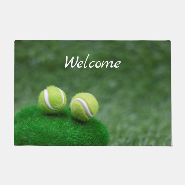 Tennis ball are on green grass doormat (Front)