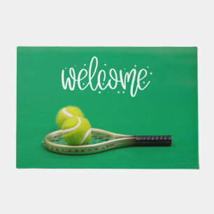 Tennis ball are on green grass welcome  doormat