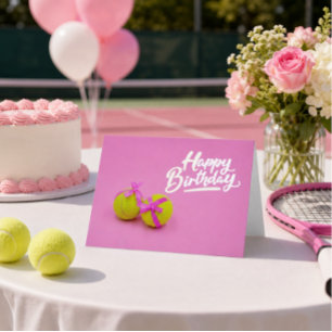 Tennis ball with pink ribbon on pink birthday card