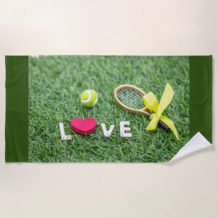 Tennis with love tennis ball and racket on green beach towel