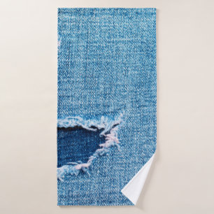 Textured denim background. Torn hole in the fabric Bath Towel