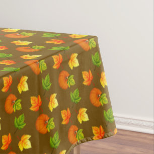 Thanksgiving Pumpkin and Fall Leaves on Brown Tablecloth