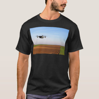 The drone is flying over the ploughed field 1 T-Shirt