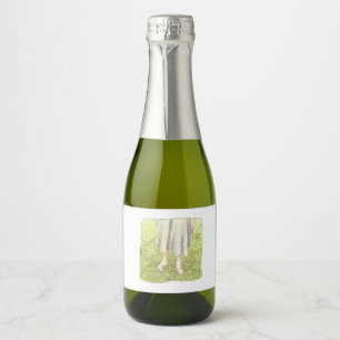 the feet of a one-piece woman standing barefoot on sparkling wine label