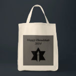 The Flame & Star - Tote Bag<br><div class="desc">This image is a flame from a candle. A star around the flame represents Hanukkah. Done in a black tattoo. A black backround was also added. "Happy Hanukkah 2014" is printed on this design. Customise with your own words. These totes are available in assorted styles,  colours and sizes.</div>