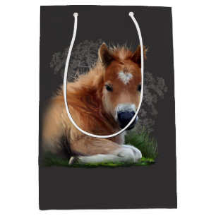 The foal is lying in the grass medium gift bag