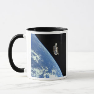 The Hubble Space Telescope with a blue earth Mug