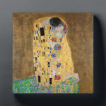 The Kiss by Gustav Klimt Plaque<br><div class="desc">The Kiss by Gustav Klimt The Kiss is an oil-on-canvas painting with added gold leaf, silver and platinum. by the Austrian Symbolist painter Gustav Klimt. It was painted at some point in 1907 and 1908, during the height of what scholars call his "Golden Period". Featuring shimmering gold tones, stylised forms,...</div>