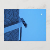 The moon hangs above the breakwater. 
