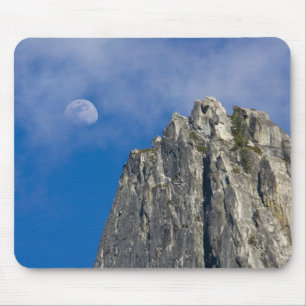 The moon rises and shines through the clouds mouse mat