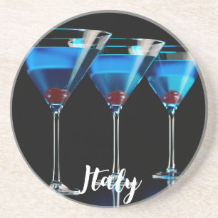Three blue cocktails with cherry on black coaster