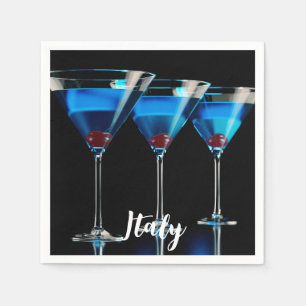 Three blue cocktails with cherry on black napkin