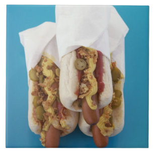 Three hot dogs in buns tile