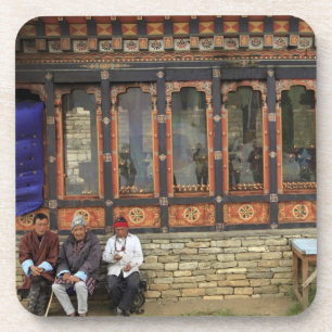 Three men sit on a bench at the Memorial Chorten Coaster