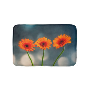 Three Orange Gerberas in a Row Bath mat