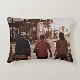 Three persons walking near palm trees decorative cushion