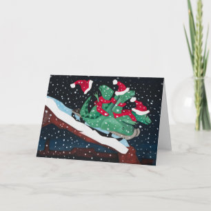 Three sledding dinosaurs holiday card