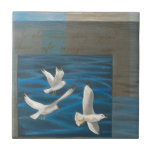 Three White Seagulls Flying Over the Water Tile<br><div class="desc">Need to get away? Do it by choosing this painting by artist Tara Friel representing three seagulls flying over the water. The sight of the waves of the ocean and the vivid colours make this design very realistic.</div>
