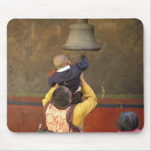 Tibetan Buddhist monk lifting a boy to ring a Mouse Mat