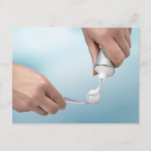 Toothpaste being squeezed onto a brush postcard