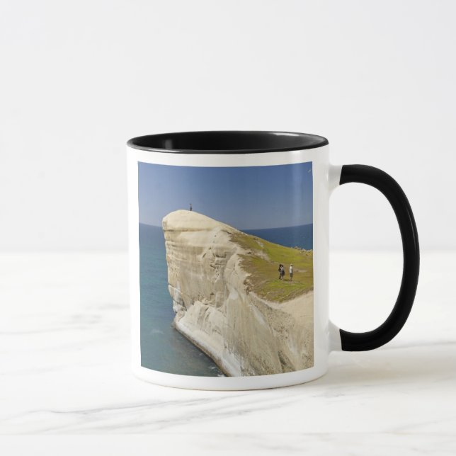 Tourists on cliff top at Tunnel Beach Mug (Right)
