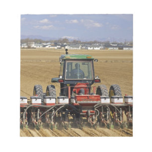 Tractor pulling a seed corn planter. notepad