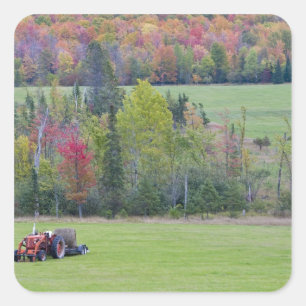 Tractor with hay bale in green field with square sticker