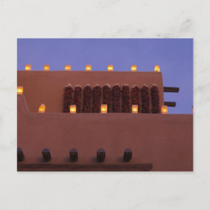 Traditional farolitos light up adobe structures postcard
