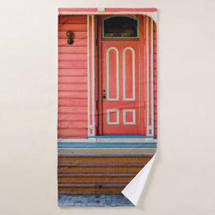 Traditional red painted wooden door and porchdoor, bath towel