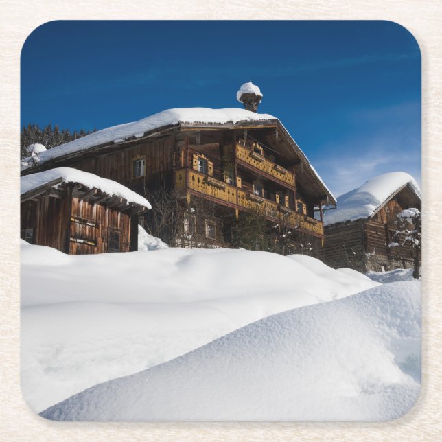 Traditional wooden cabins in de snow square paper coaster (Front)