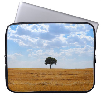 Tree in an harvested wheat field laptop sleeve