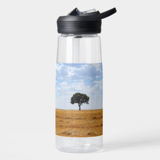 Tree in an harvested wheat field water bottle