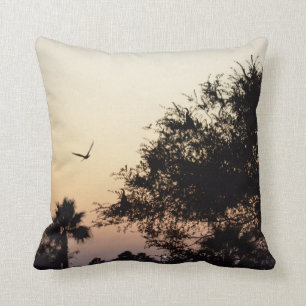 trees and flying bird against florida sunset cushion