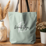 Trendy Sage Green Black White Script Monogram  Tote Bag<br><div class="desc">This elegant personalised tote bag features a monogram and first name in modern black and white script on a trendy sage green background.</div>