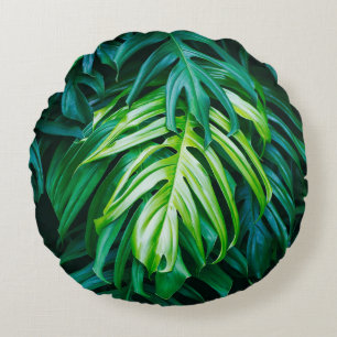 Tropical green leaves on dark background, nature s round cushion