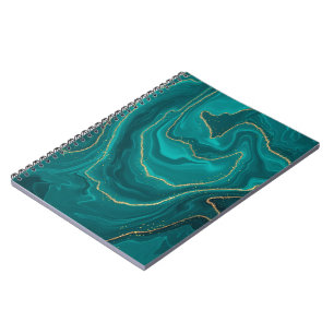 Turquoise liquid marble background with gold notebook