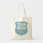 Turquoise Team Bride tote bags for wedding party<br><div class="desc">Turquoise Team Bride tote bags for wedding party. Personalizable with name. Cute gift idea for bride,  bridesmaids,  maid of honour,  mum,  sister,  friends etc. Pink emblem badge design for wedding party,  bridal shower,  bachelorette girls night out. Elegant script letters. Turquoise blue and white colours.</div>