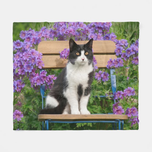 Tuxedo cat sitting on a garden chair with flowers fleece blanket (Front (Horizontal))