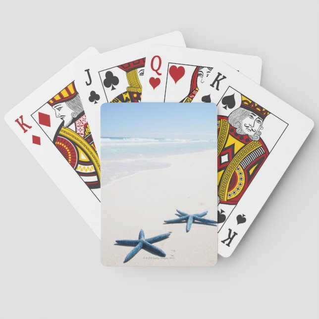Two blue starfish at water's edge on tropical playing cards (Back)