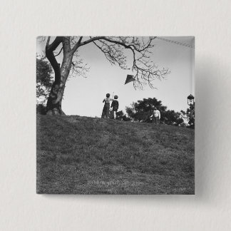 Two boys flying kite on hill B&W 15 Cm Square Badge