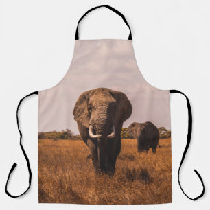 TWO ELEPHANTS WALKING ON GRASS COVERED GROUND APRON