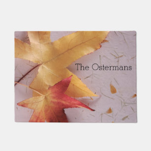 Two fall leaves on texture doormat