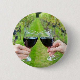 Two hands toasting with wine glasses in vineyard 6 cm round badge