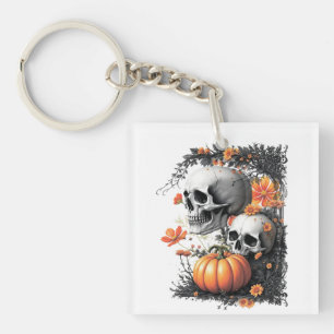 Two skulls and a pumpkin among flowers. key ring