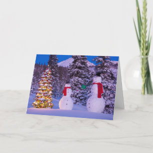 Two Snowmen Exchange Gifts by the Tree Holiday Card