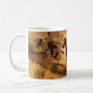 Two western cowboys riding horses, roping wild hor coffee mug