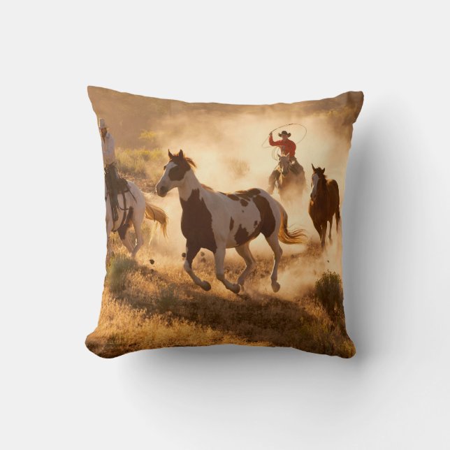 Two western cowboys riding horses, roping wild hor cushion (Front)