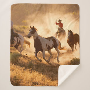 Two western cowboys riding horses, roping wild hor sherpa blanket