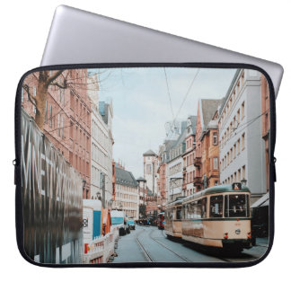 TWO WHITE TRAINS BESIDE BUILDINGS LAPTOP SLEEVE