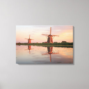 Two windmills with reflection at sunset canvas print
